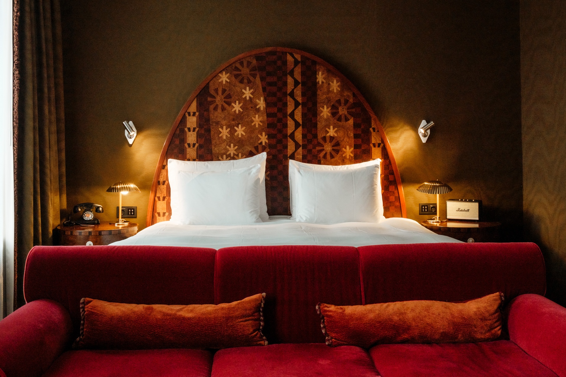 Marquetry arched headboard with red velvet sofa at Sommerro House