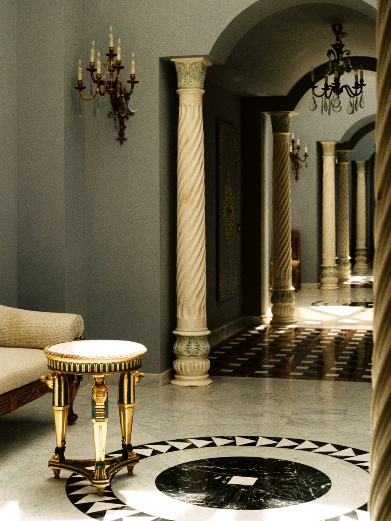 Marble hallway with spiral columns and crystal sconces