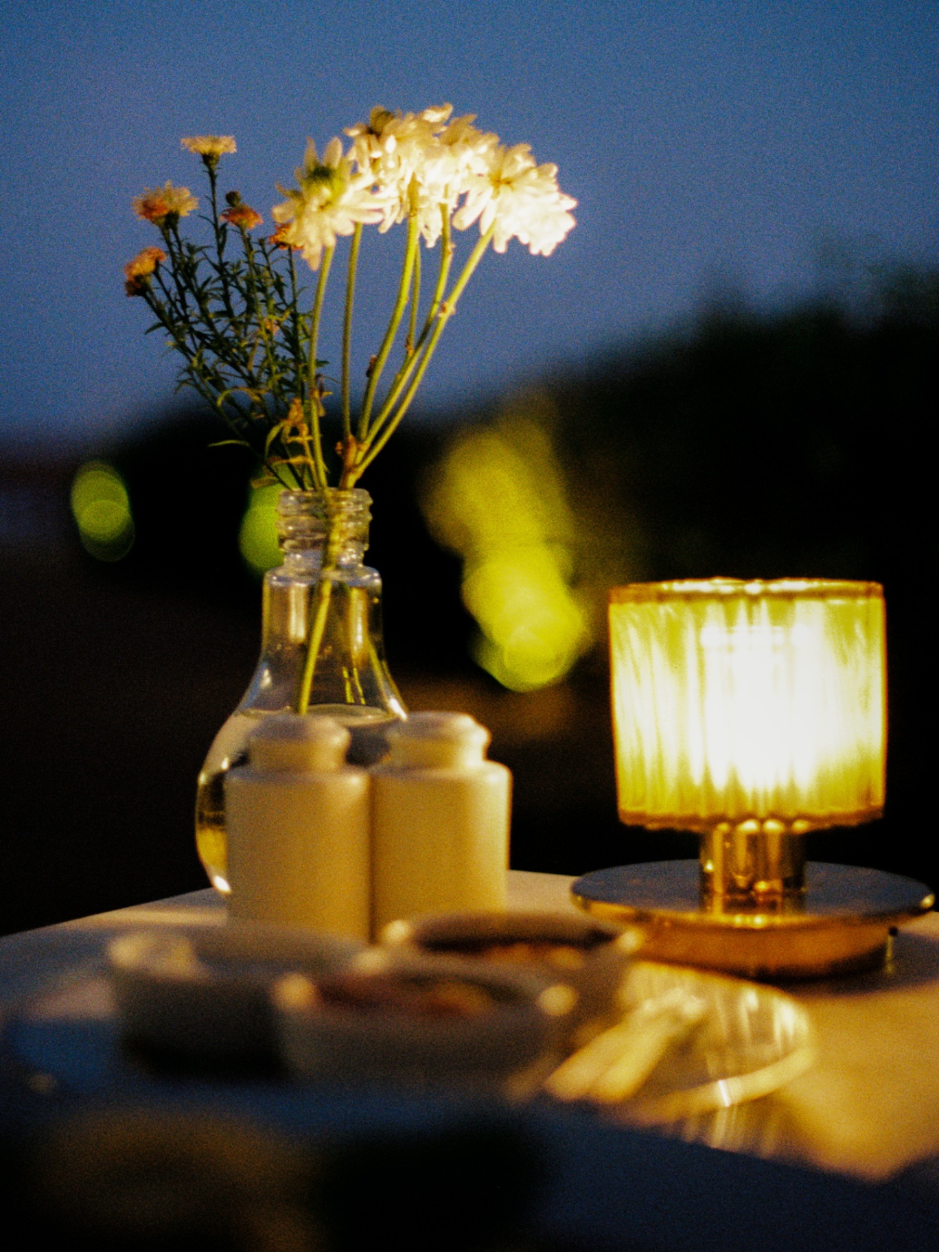 Wildflowers and candlelight on a dusk dining table
