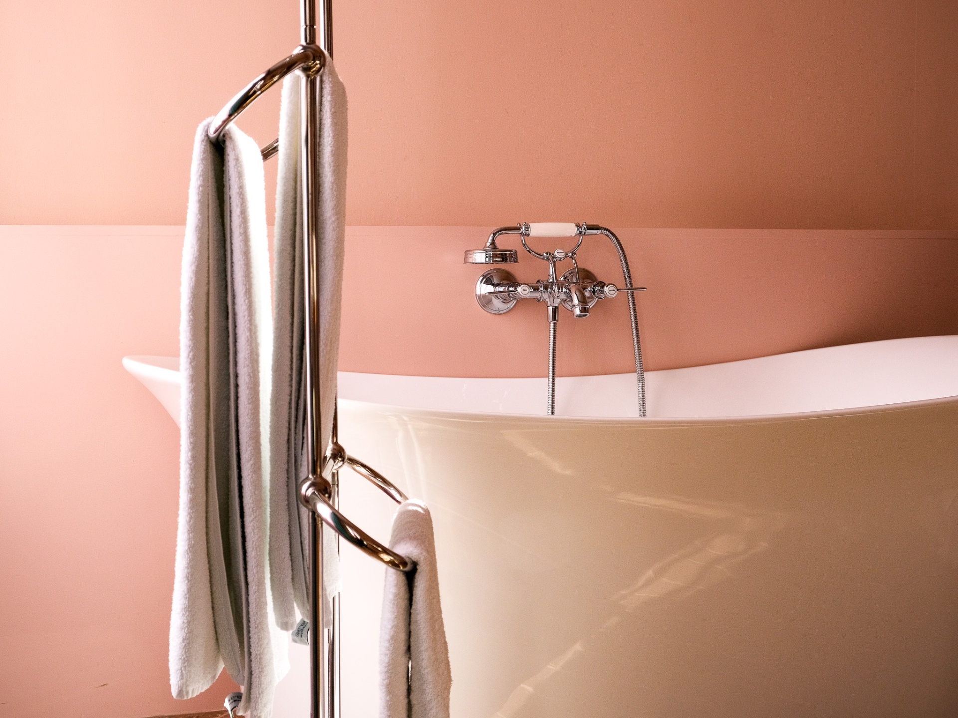 Freestanding bathtub against soft peach walls