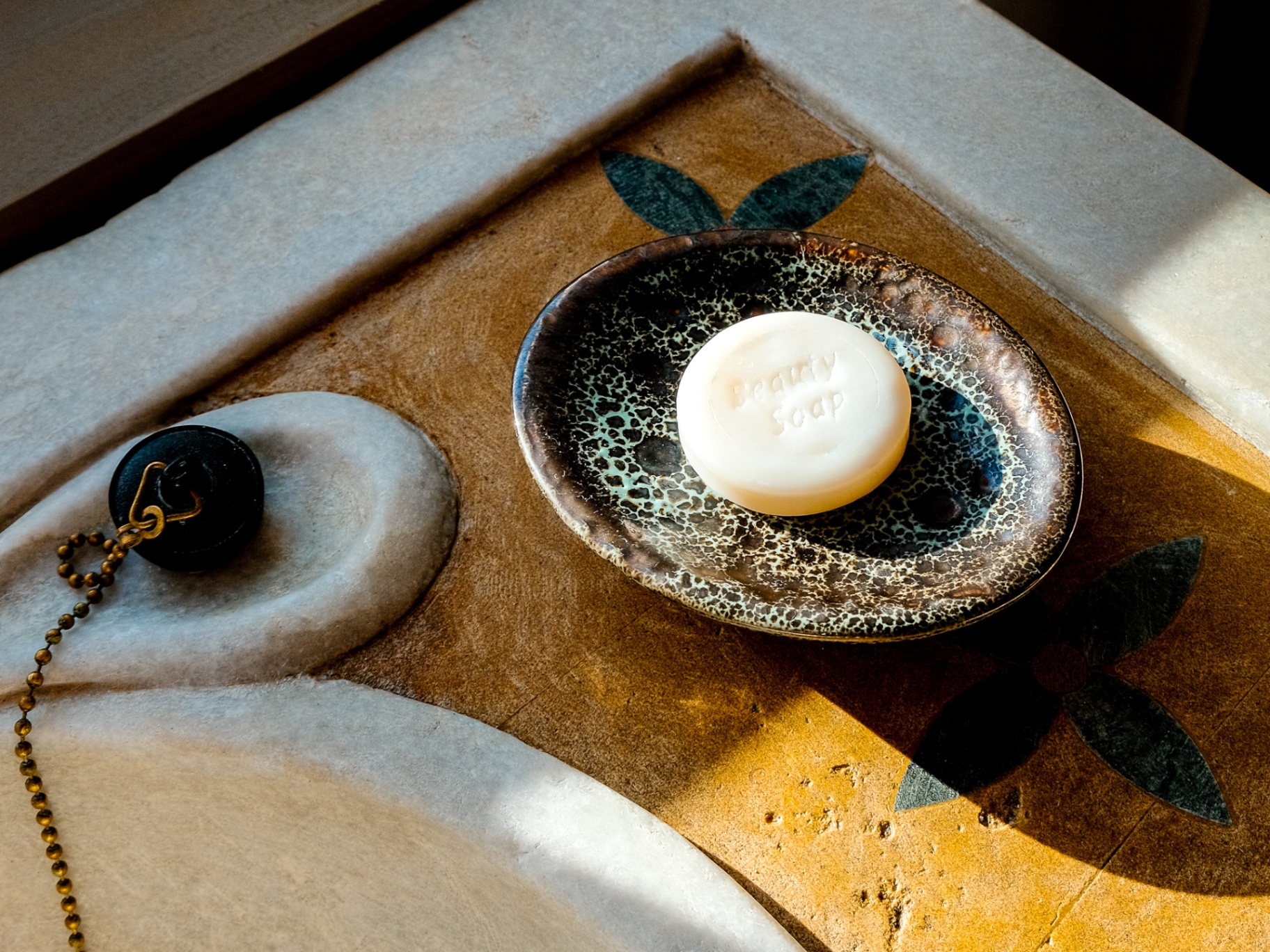 Hand-poured beauty soap on a ceramic dish, marble sink still life