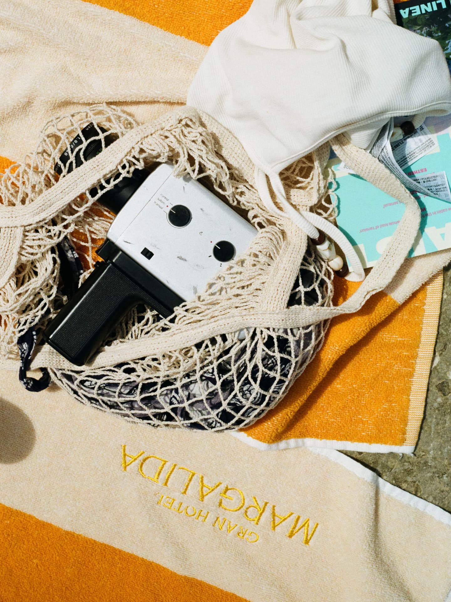 Super 8 camera in a net bag on a Gran Hotel Margalida beach towel