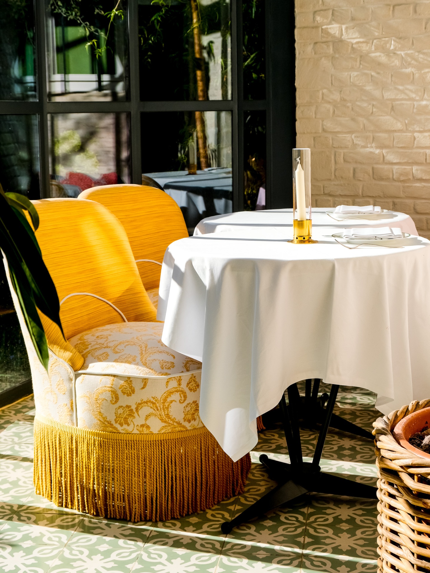 Yellow fringed chair beside a sunlit terrace table