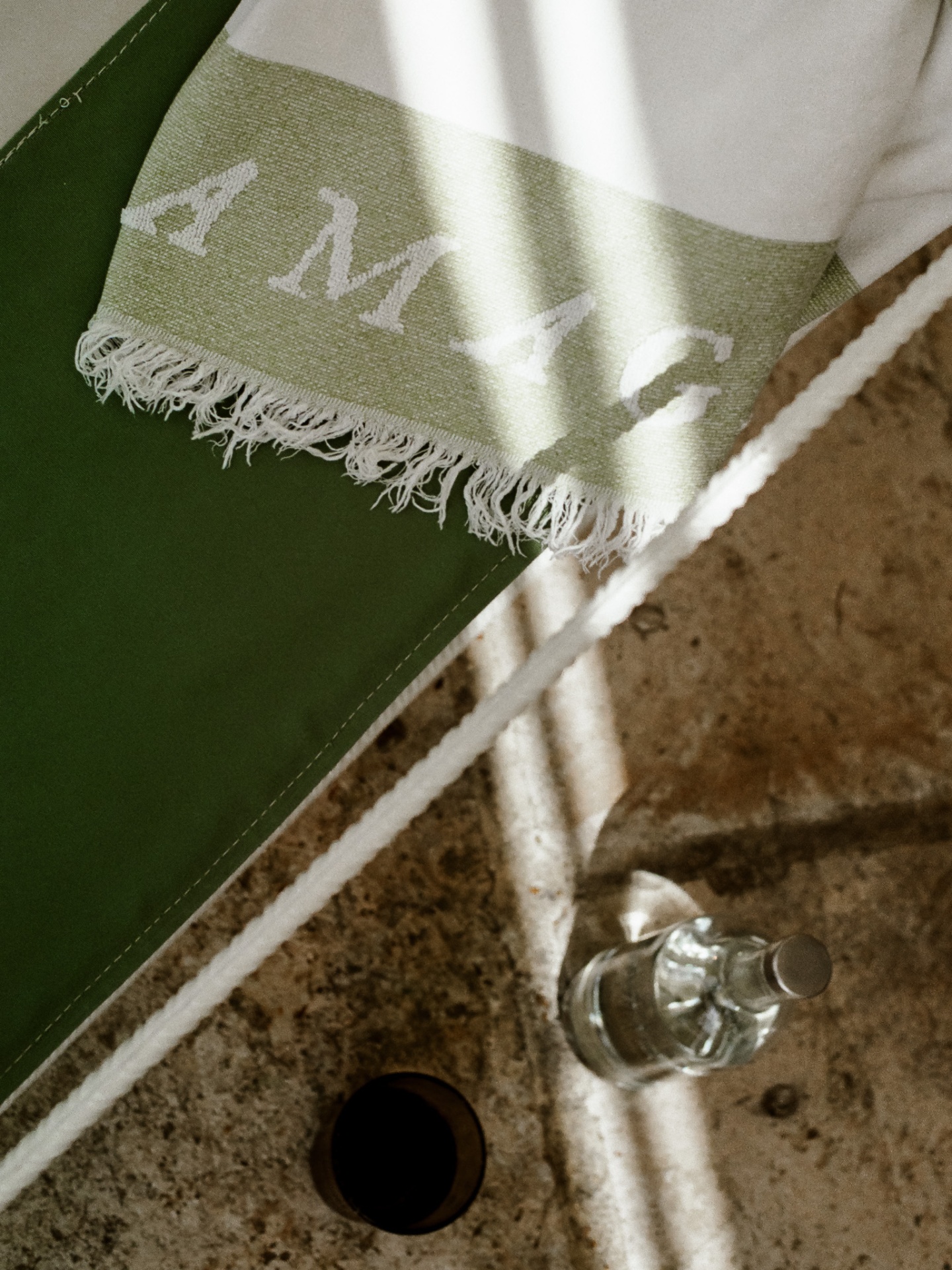 Detail of an Amagatay green striped towel on stone